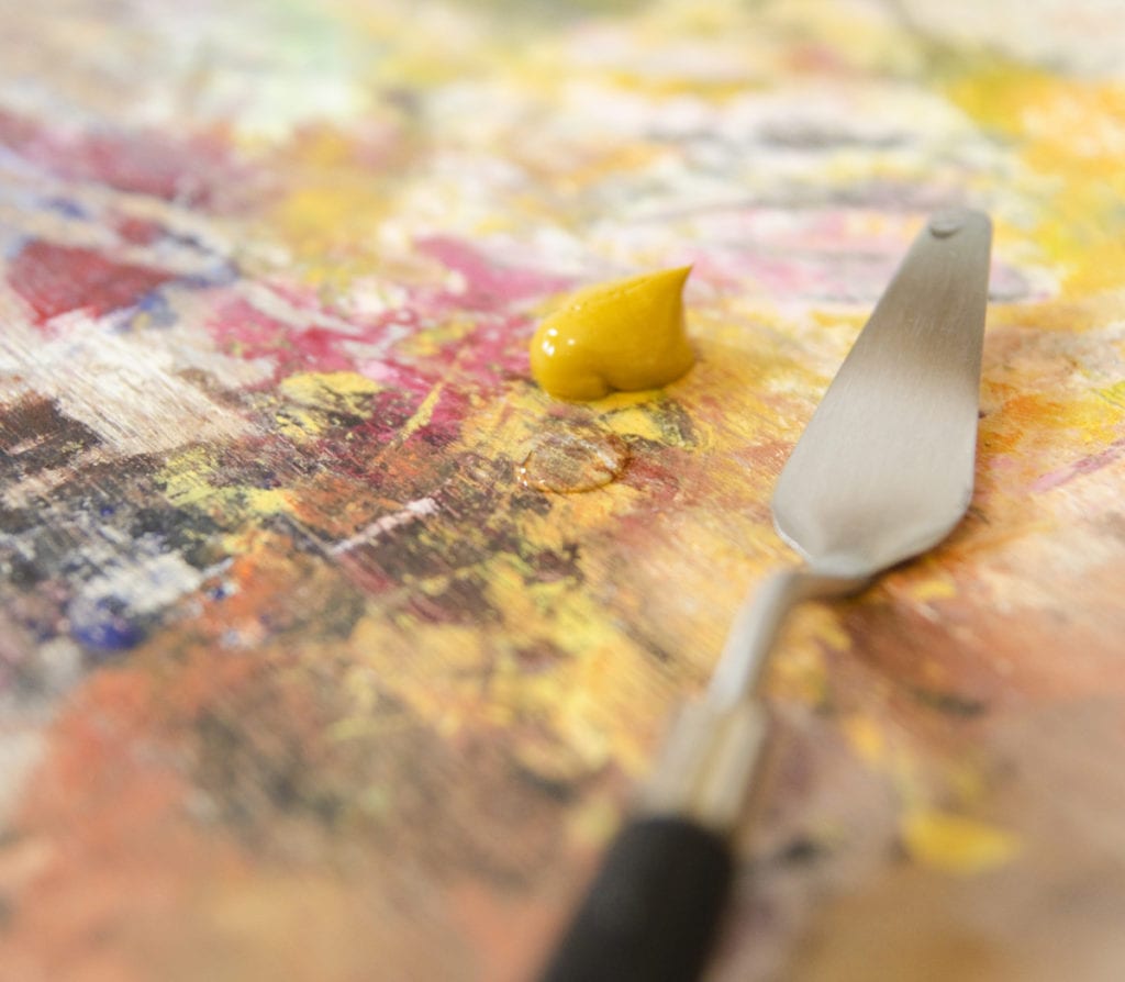 thinning yellow ochre oil paint with water on the palette
